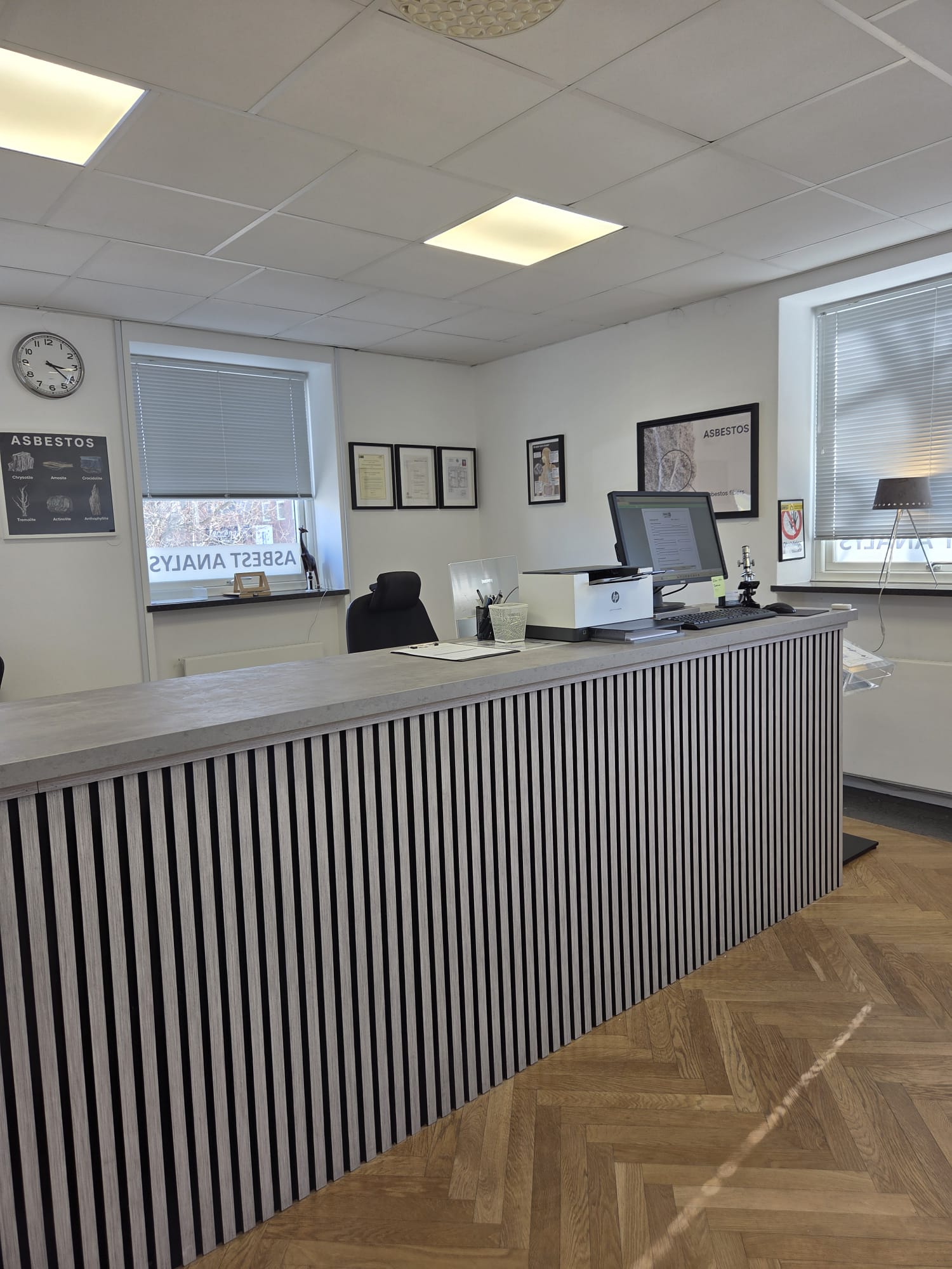 ONEX Lab – receptionsdisk med certifikat på väggen